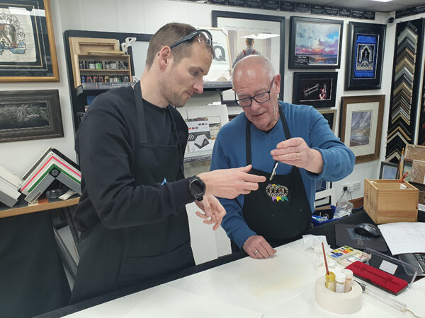 Ian showing Stuart how to add paint to a ruling pen